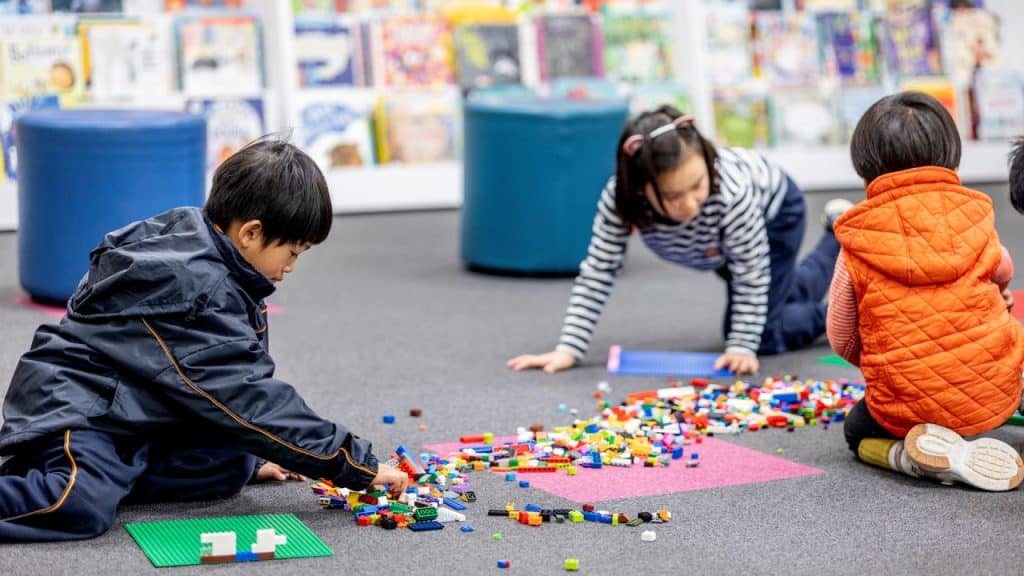 Children playing with lego on the floor