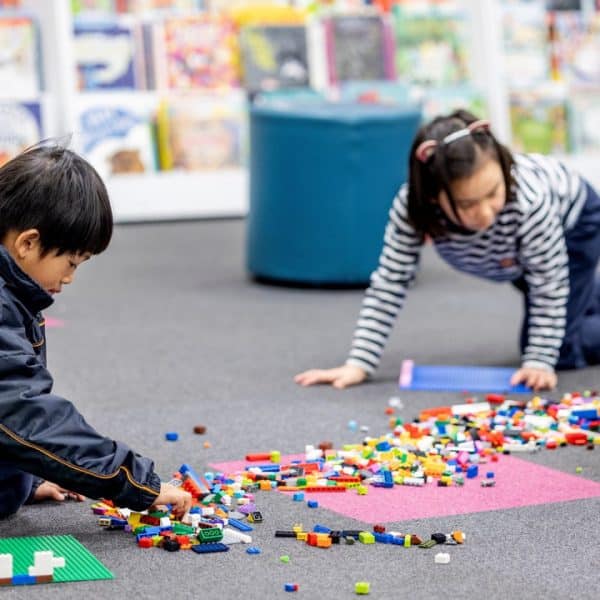 Children playing with lego on the floor