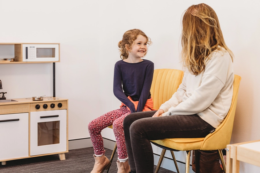 - A child and her parent waiting for the start of their therapy session