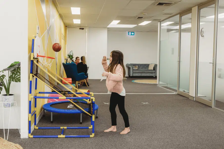 - A child shooting a hoop as part of a speech therapy activity