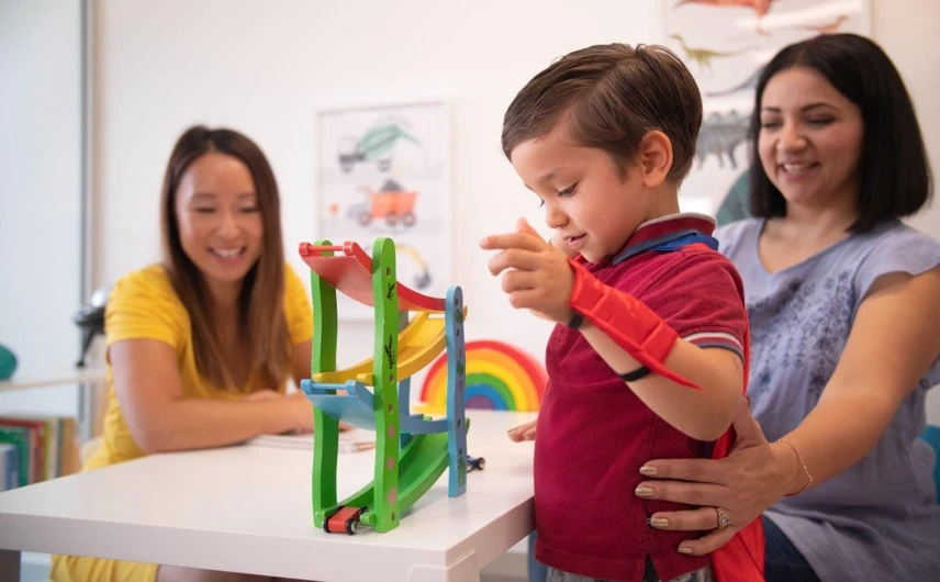 - A parent assisting her son in a therapy session
