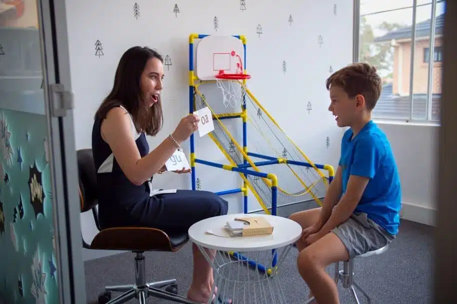 - A speech therapist using flash cards of letter pairs during therapy for literacy development
