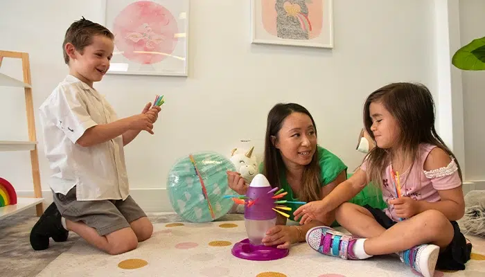 Speech-pathologist-playing-with-boy-and-girl-as-an-action-to-address-receptive-language-disorder
