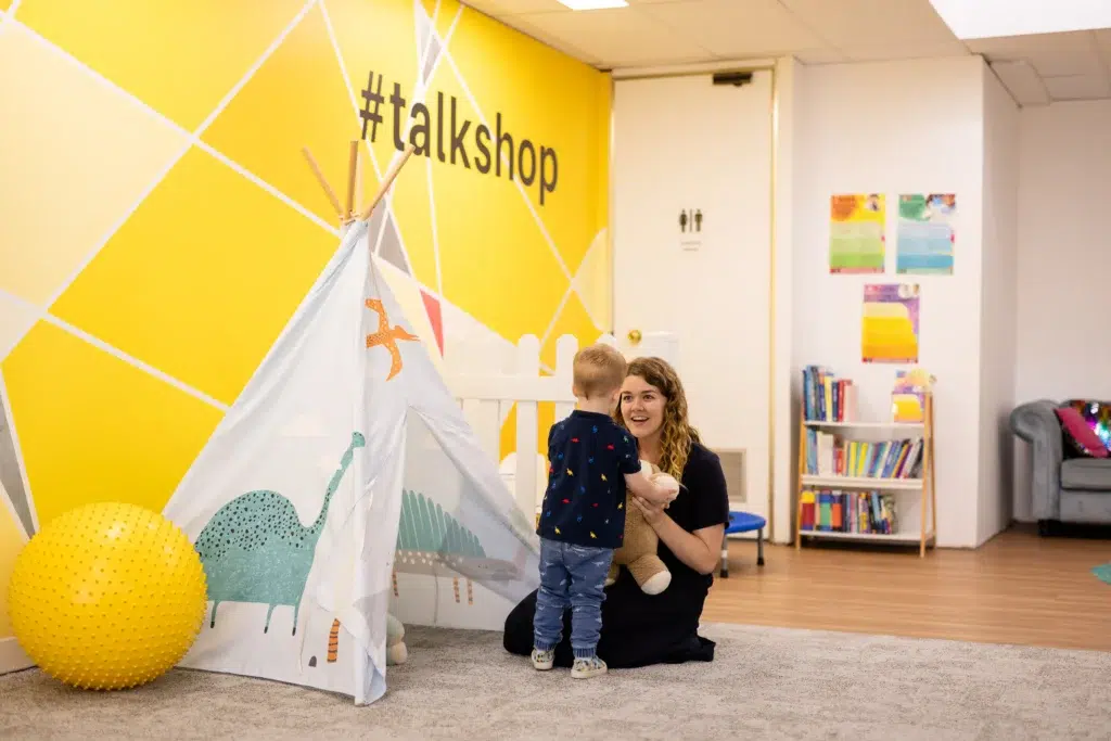 Lady-speech-pathologist-helping-a-young-boy-holding-a-stuffed-toy-during-a-speech-pathology-session