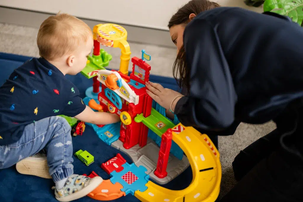 Speech-therapist-helping-a-young-boy-build-a-fire-station-during-an-expressive-language-speech-therapy-session.