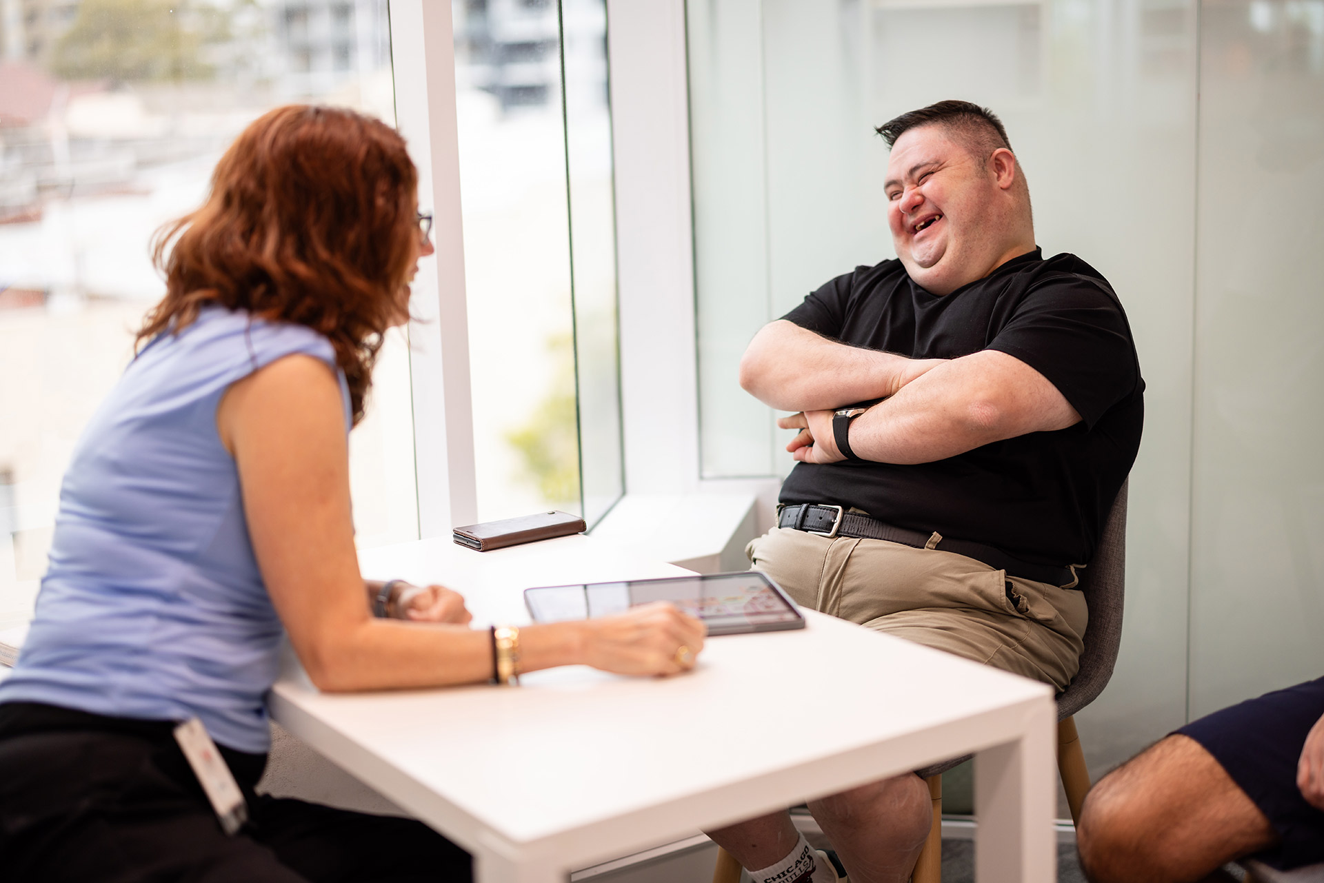Adult client smiling during a friendly Speech Pathology Ashfield session with a therapist.