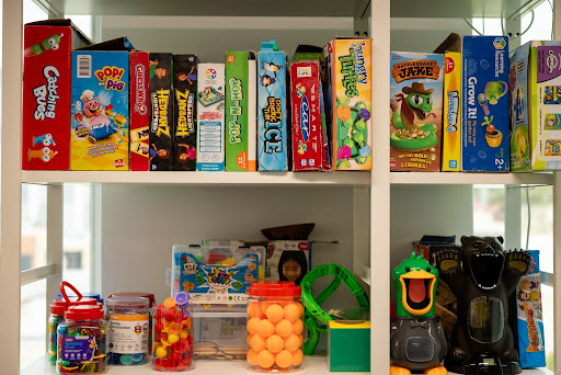 Therapy shelf filled with kids’ games and toys – Speech Pathology Ashfield.
