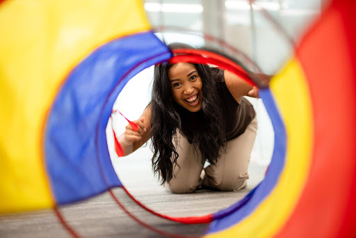 Therapist playfully encouraging a child through a tunnel – Speech Pathology Ashfield.