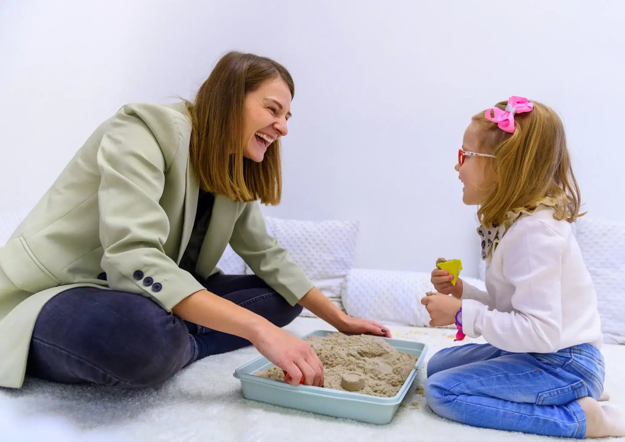 Speech pathologist and young girl building sandcastles to improve language and organisation in ADHD treatment
