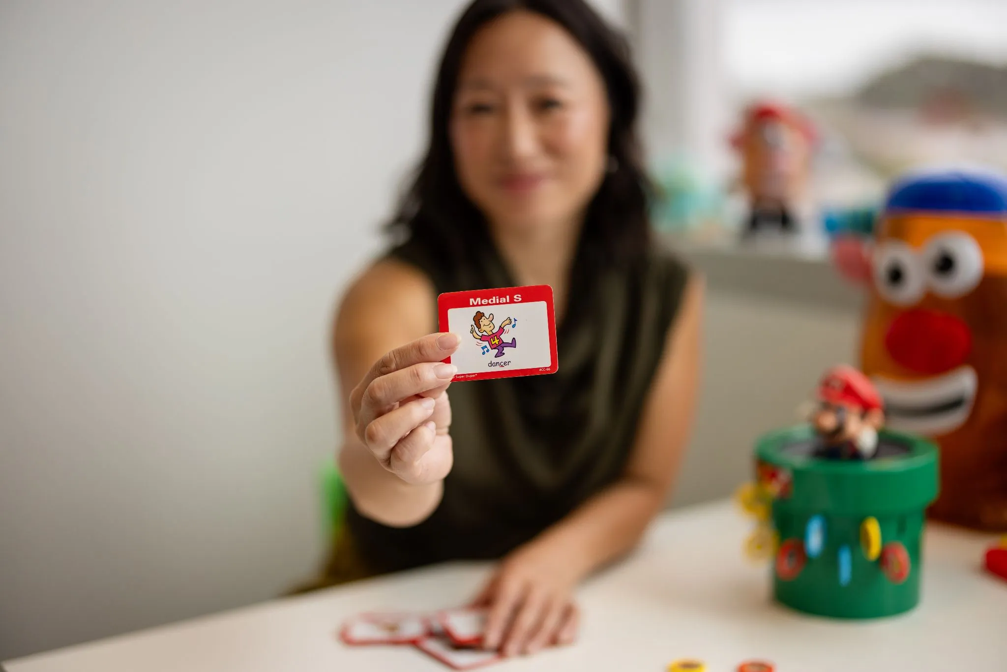 Speech therapist holding a phonics card during a session for speech pathology for dyslexia.