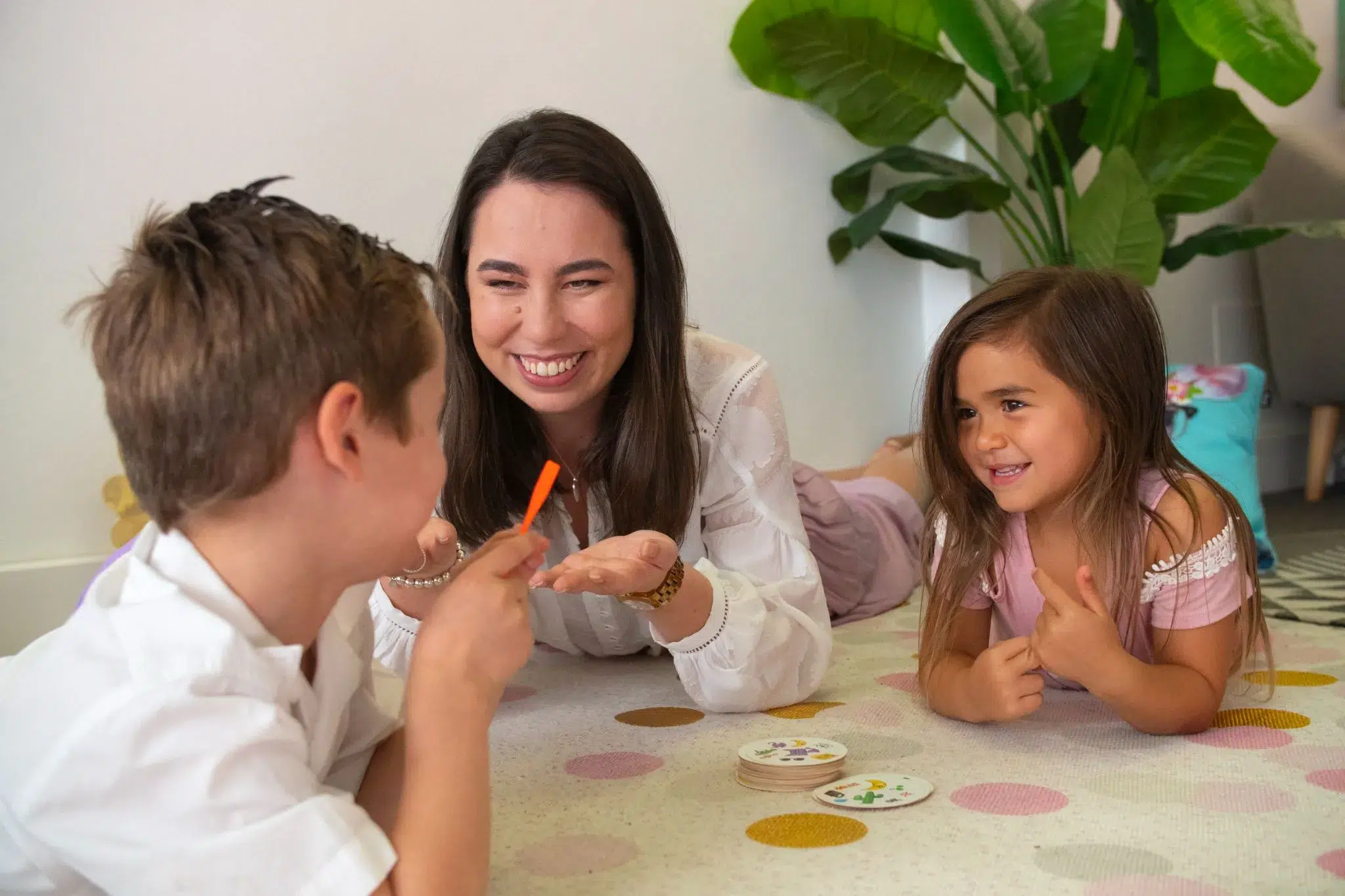 A young girl smiling and engaging in a play-based speech therapy session, used to assess and treat a articulation disorder.