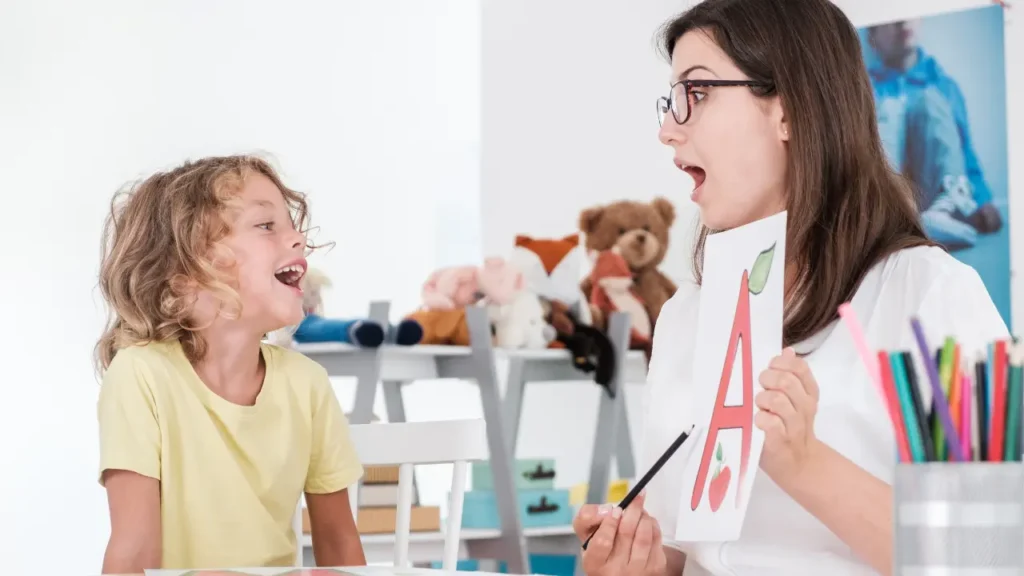 Speech pathologist providing speech therapy for kids during an NDIS session with a young participant