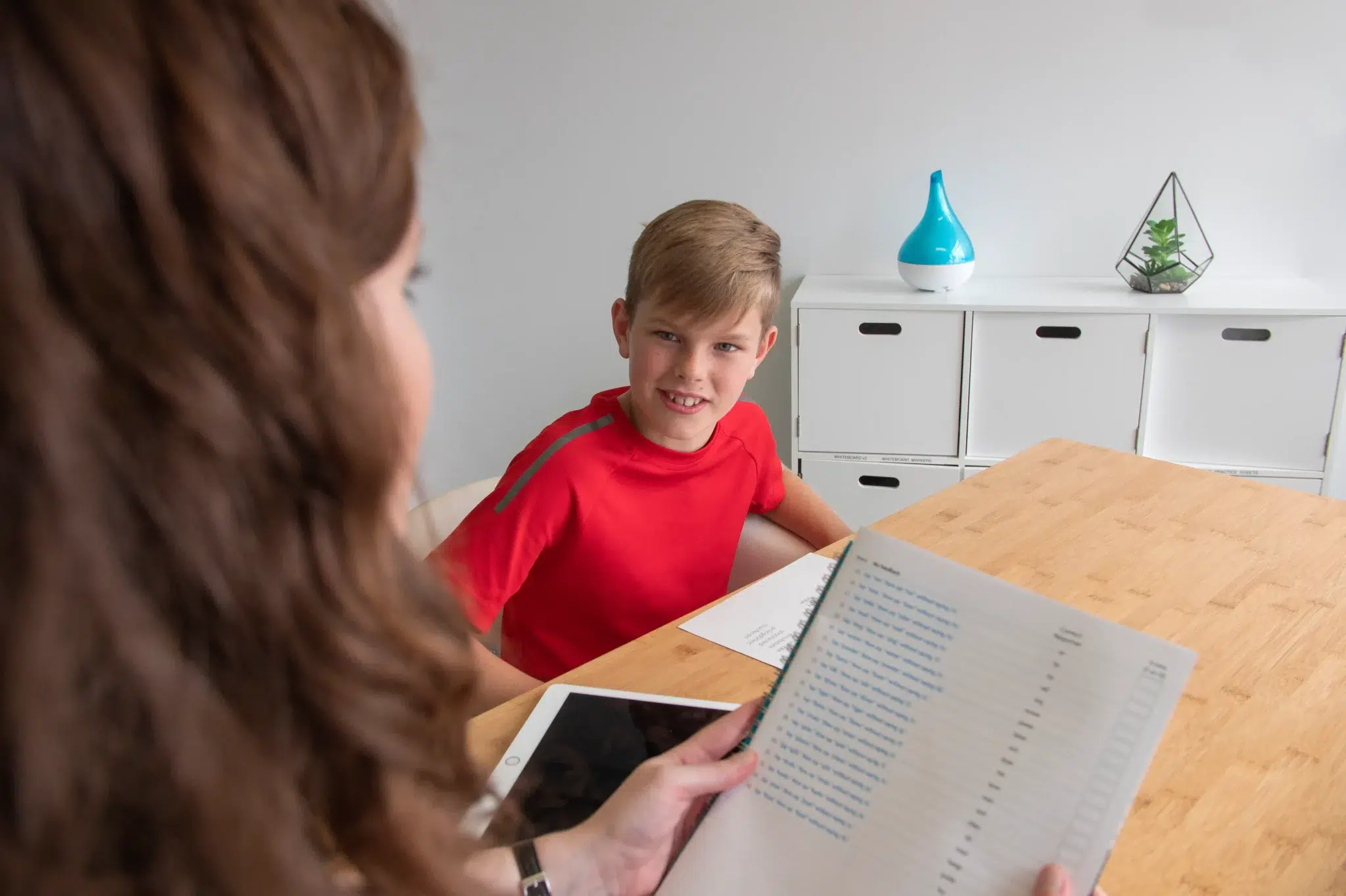 Young boy during a speech and myofunctional assessment with a therapist at a table